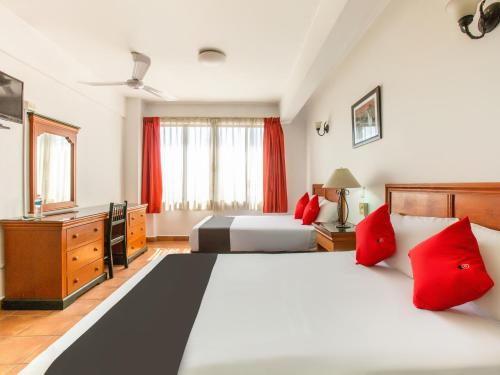 een slaapkamer met 2 bedden en rode kussens bij Hotel Santa Lucia in Oaxaca City