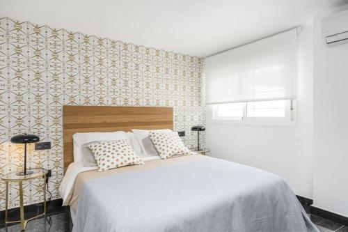 a bedroom with a large bed and a wall at Apartamento Pedregalejo Beach Playa in Málaga