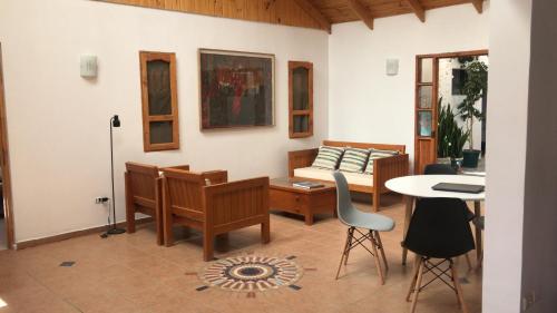 a living room with a couch and a table and chairs at Hostal Casa 95 in Vicuña