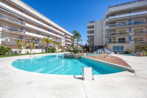 an empty swimming pool in front of a building at Port Canigó 344 in Roses