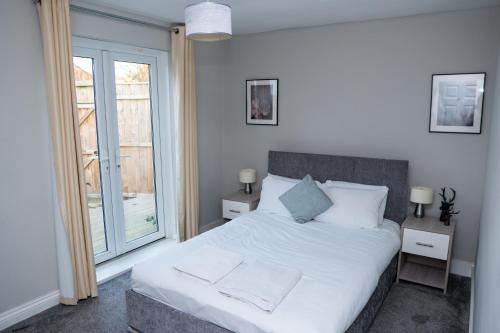 a bedroom with a white bed and a large window at Luke Stays - Front Street in Newcastle upon Tyne