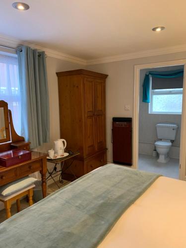 a bedroom with a bed and a desk and a toilet at The Old Coach House in Blackpool