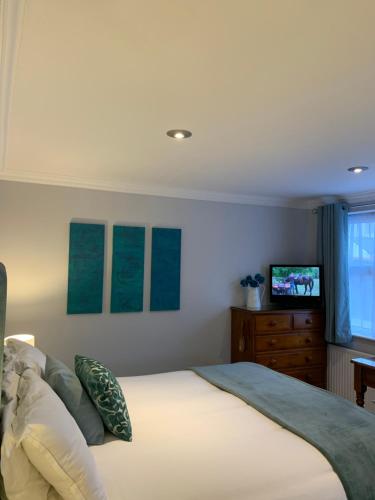 a bedroom with a large bed and a television at The Old Coach House in Blackpool