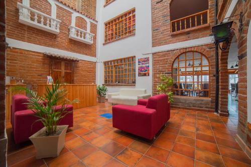 a living room with red chairs and a table at El Andariego in Otavalo