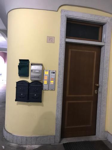 une porte menant à un bâtiment avec deux machines à côté de celui-ci dans l'établissement “Coccole nel borgo” 2min to outlet, à Serravalle Scrivia