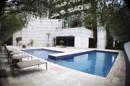 a swimming pool in front of a building at Flat 4 Estrelas Jardins in São Paulo