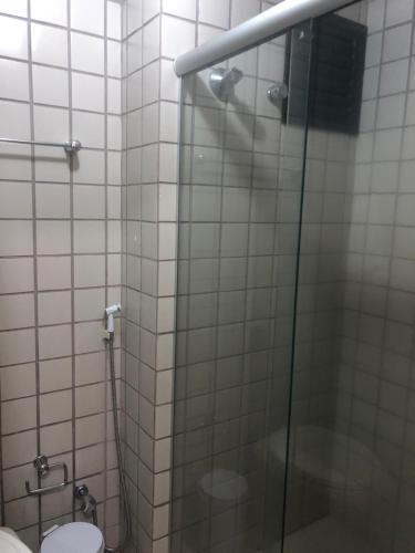 y baño con ducha de cristal y aseo. en Melo Hospedagem - Flat Bellagio, en São Luís