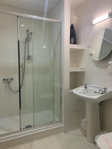 a bathroom with a glass shower and a sink at The Beaufort Hotel in Chepstow