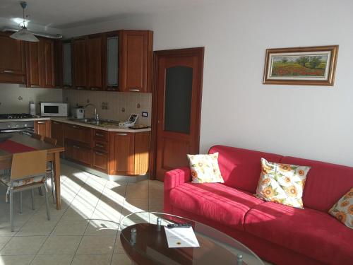 un soggiorno con divano rosso e una cucina di IL GIRASOLE a Tirano