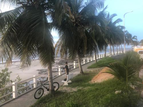 a man walking his bike on a path near the beach at Melo Hospedagem - Flat Bellagio in São Luís