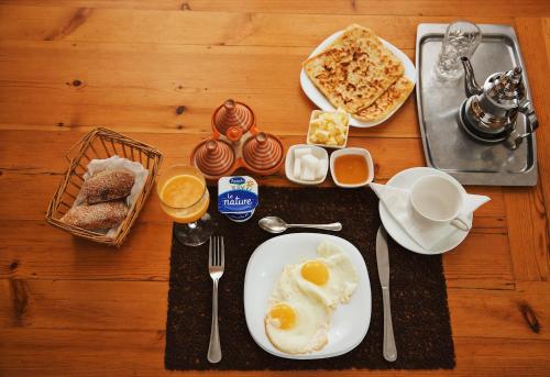 a table with a plate of eggs and other breakfast foods at Dar Liouba Hotel in Essaouira