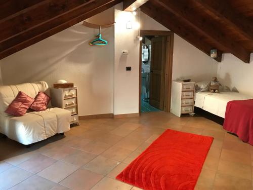 a living room with two beds and a red rug at Viaggio della Vita B&B in Fontanile