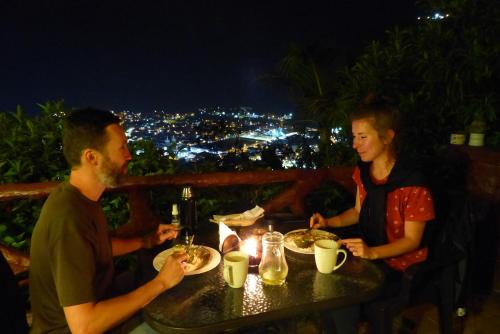 a man and woman sitting at a table with plates of food at La Casa Amarilla in Baños
