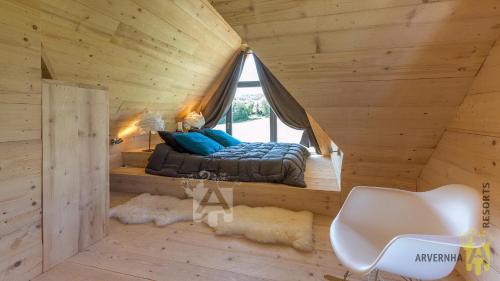 Posto letto in una baita di tronchi con finestra. di Chalet des Marmottes a Besse-et-Saint-Anastaise