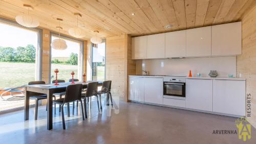 une cuisine et une salle à manger avec une table et des chaises dans l'établissement Chalet des Marmottes, à Besse-et-Saint-Anastaise