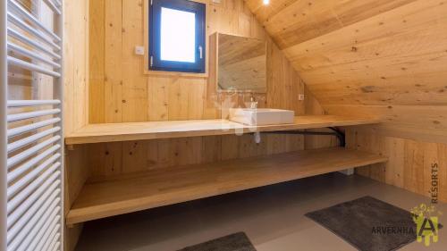 a bathroom with a sink in a wooden cabin at Le Sancy in Besse-et-Saint-Anastaise