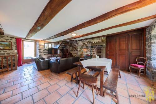 un salon avec une table et quelques chaises dans l'établissement Vie de Château 2, à Murol