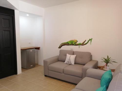 a living room with a couch and a dinosaur on the wall at La Sirena Playa Jacó in Jacó