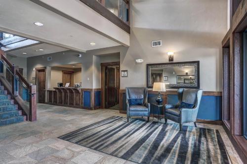 a lobby with two chairs and a table and a mirror at Crystal Peak Lodge By Vail Resorts in Breckenridge