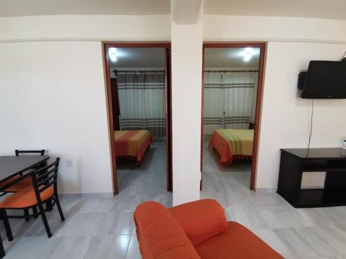 a living room with a couch and a desk and a bedroom at DEPARTAMENTOS OAXACA MÁGICO in Oaxaca City