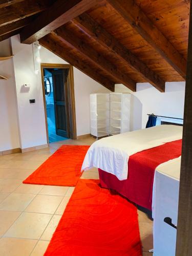 a bedroom with a bed and red rugs at Viaggio della Vita B&B in Fontanile