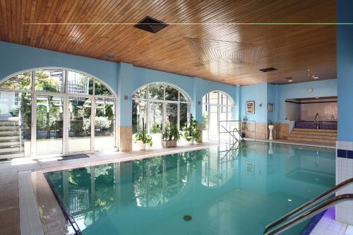 an indoor swimming pool with blue walls and a wooden ceiling at Best Western Hotel de Havelet in St Peter Port