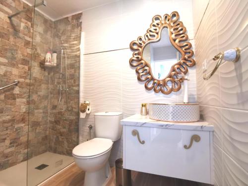 a bathroom with a toilet and a mirror on the wall at Puerta del Sol casa Lily Caleta de Fuste in Caleta De Fuste