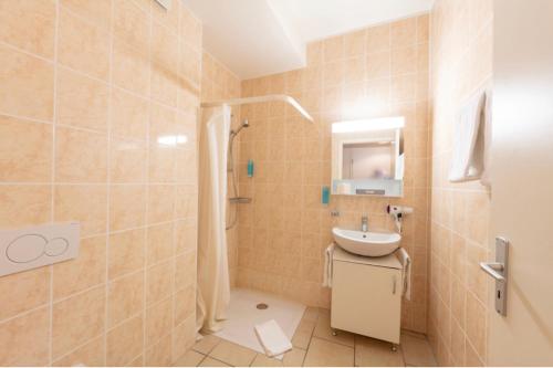 ein Bad mit einem Waschbecken und einer Dusche in der Unterkunft Hostellerie de L'Hôtel de Ville in Vevey