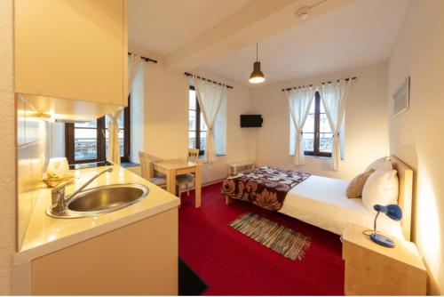 a bathroom with a bed and a sink in a room at Hostellerie de L'Hôtel de Ville in Vevey