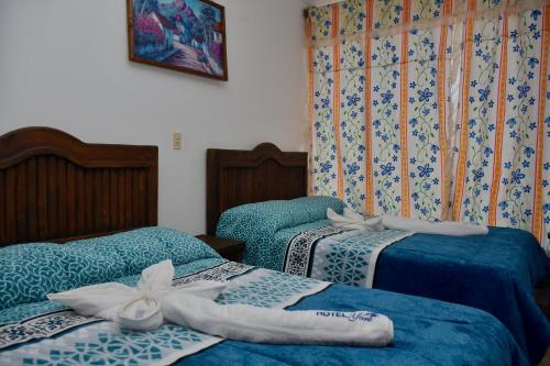 Dos camas en una habitación con toallas encima. en Hotel Yara, en Ixtapan de la Sal