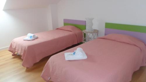 two beds in a room with pink and green at Casa Férias Melides in Melides
