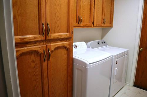 a kitchen with a washing machine and wooden cabinets at Blue Jay Paradise in Three Rivers