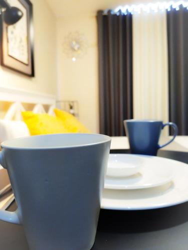 a table with two cups and plates on it at BH Mangrove Condos in Mactan