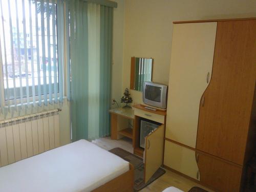 a small room with a tv and a desk with a television at Hotel Tsarevets in Asenovgrad