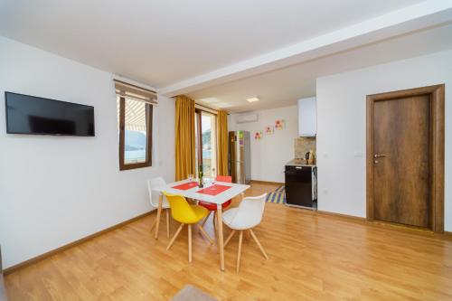 a dining room with a table and yellow chairs at Vila Fortuna in Sutomore