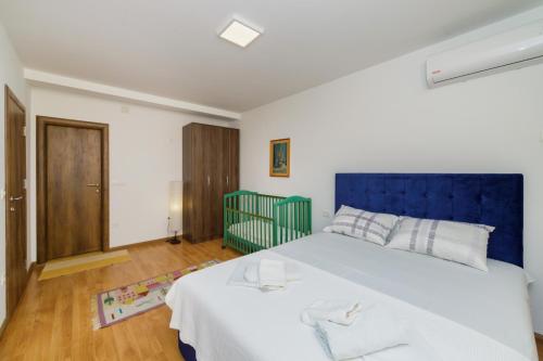 a bedroom with a large bed with a blue headboard at Vila Fortuna in Sutomore