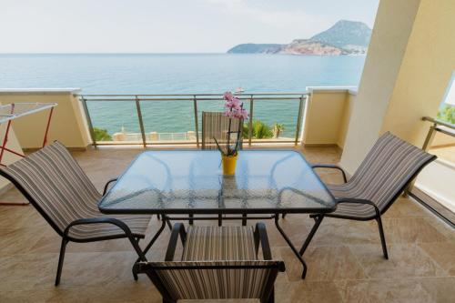 a glass table and chairs on a balcony with the ocean at Vila Fortuna in Sutomore