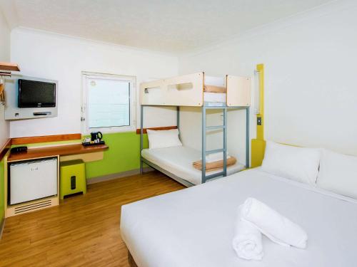 a bedroom with a bed and a bunk bed at ibis Budget Brisbane Airport in Brisbane