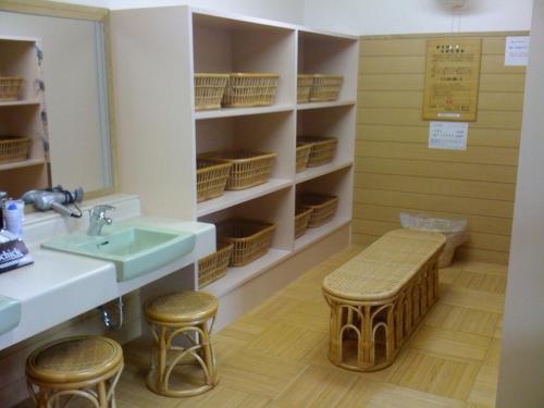 łazienka z umywalką, lustrem i stołkami w obiekcie Genpeiso w mieście Shimonoseki