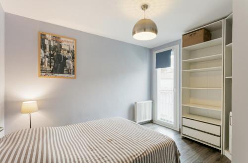 una camera con letto, scaffali e finestra di Appartement T4 Centre Ville Séte tout confort 3 chambres a Sète