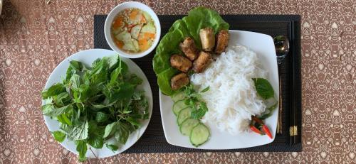 a tray with two plates of food and a salad at BBQ Hostel Ha Long 2 in Ha Long
