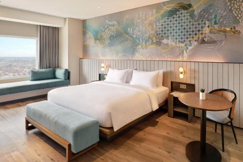 a bedroom with a large bed and a table at Mercure Bengkulu in Bengkulu
