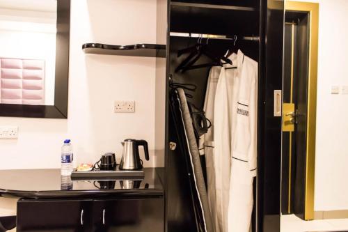 uma cozinha com um frigorífico preto e um lavatório em Parkside Plaza Muscat em Mascate