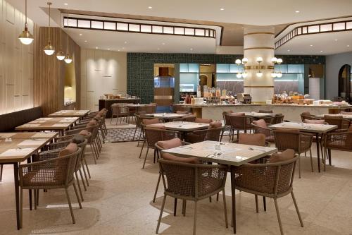 a restaurant with tables and chairs and a bar at Mercure Bengkulu in Bengkulu