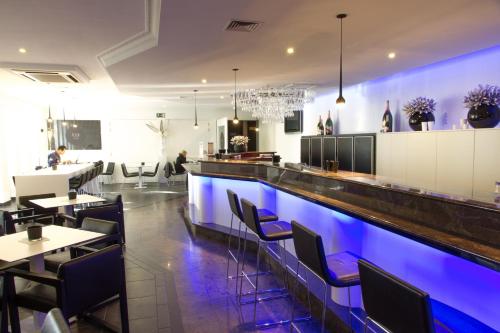 a bar with blue lighting in a restaurant at Best Western Plus Aldhem Hotel in Grobbendonk
