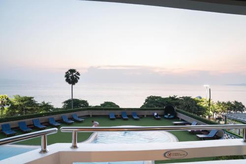 a view of the pool and ocean from the balcony of a hotel at Grand Jomtien Palace Hotel - SHA Extra Plus in Jomtien Beach