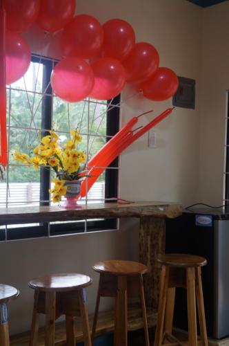 a bunch of red balloons hanging over a counter with stools at Camiguin VIAJEROS House Rental in Compol