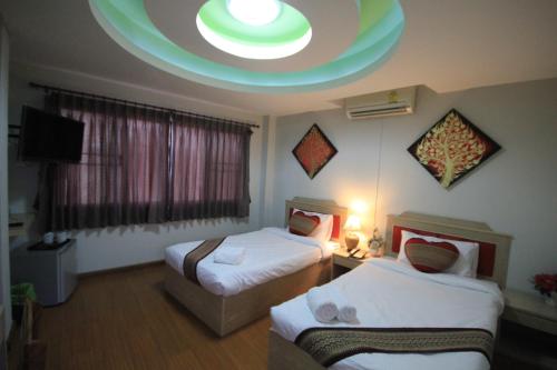 a hotel room with two beds and a round ceiling at Home Place Hotel in Chiang Mai