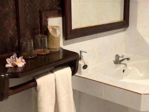 a bathroom with a sink and a mirror and towels at Mekong Riverside Lodge in Pakbeng