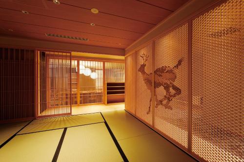 a room with a room with a wall of glass at Daiwa Roynet Hotel Nara Natural Hot Spring in Nara